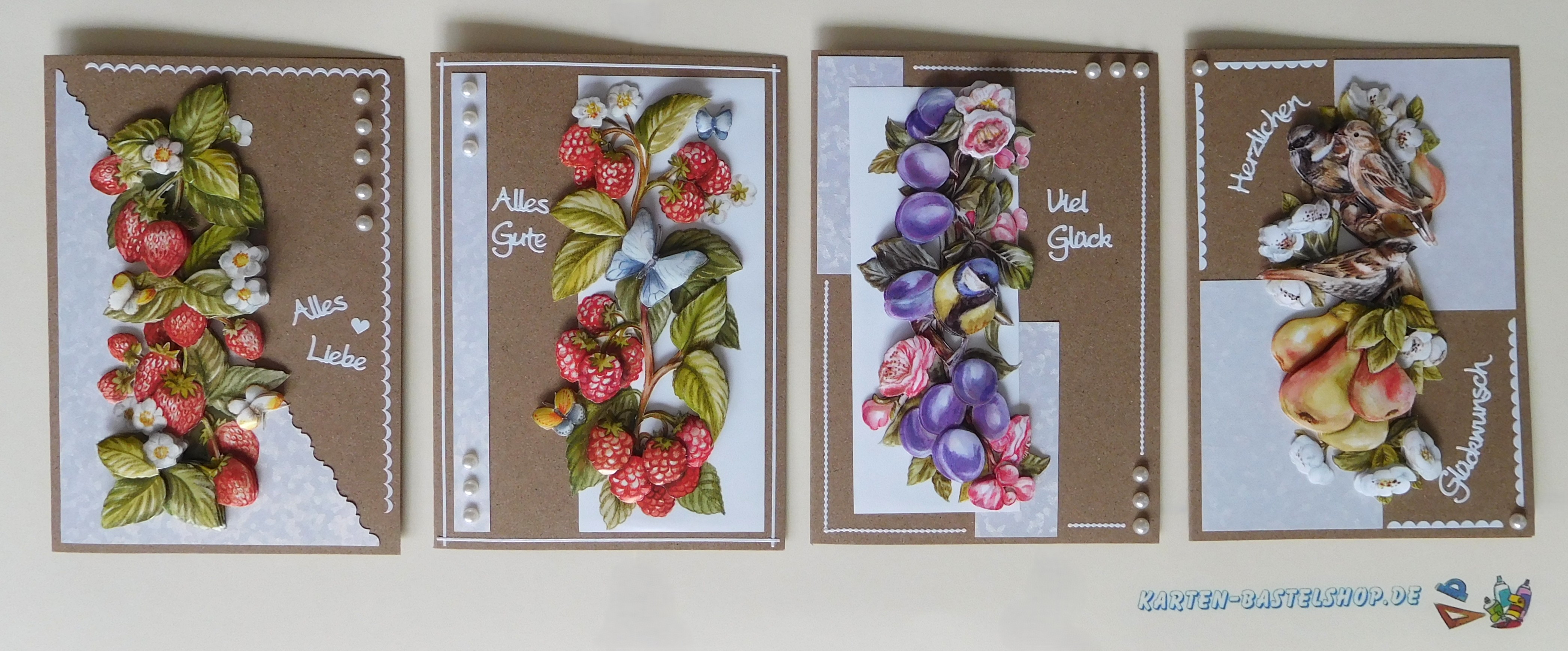 Vier selbst gebastelte 3D-Karten mit Erdbeeren, Himbeeren, Pflaumen und Birnen