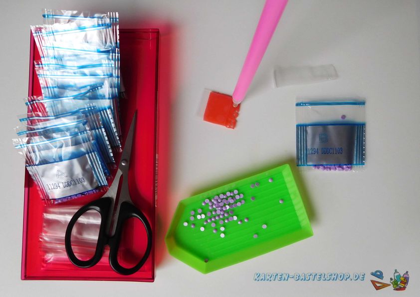 Diamond-Painting-Steinchen in Tütchen, Schere, Schiffchen und Zubehör