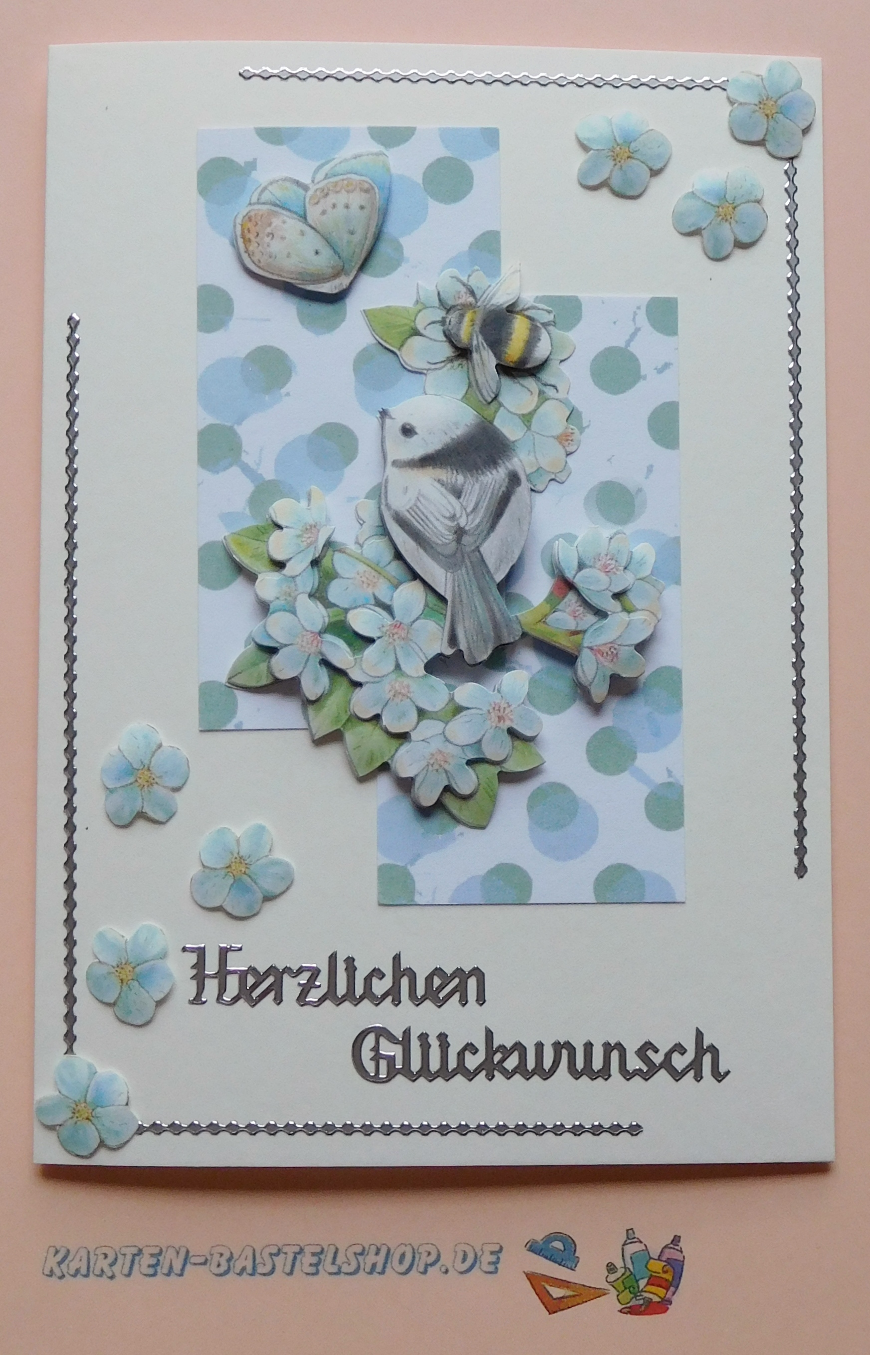 Glückwunschkarte mit Vogelmotiv, Blüten und Punkten in hellen Blautönen aus dem Stanzbogenbuch Nr. 21