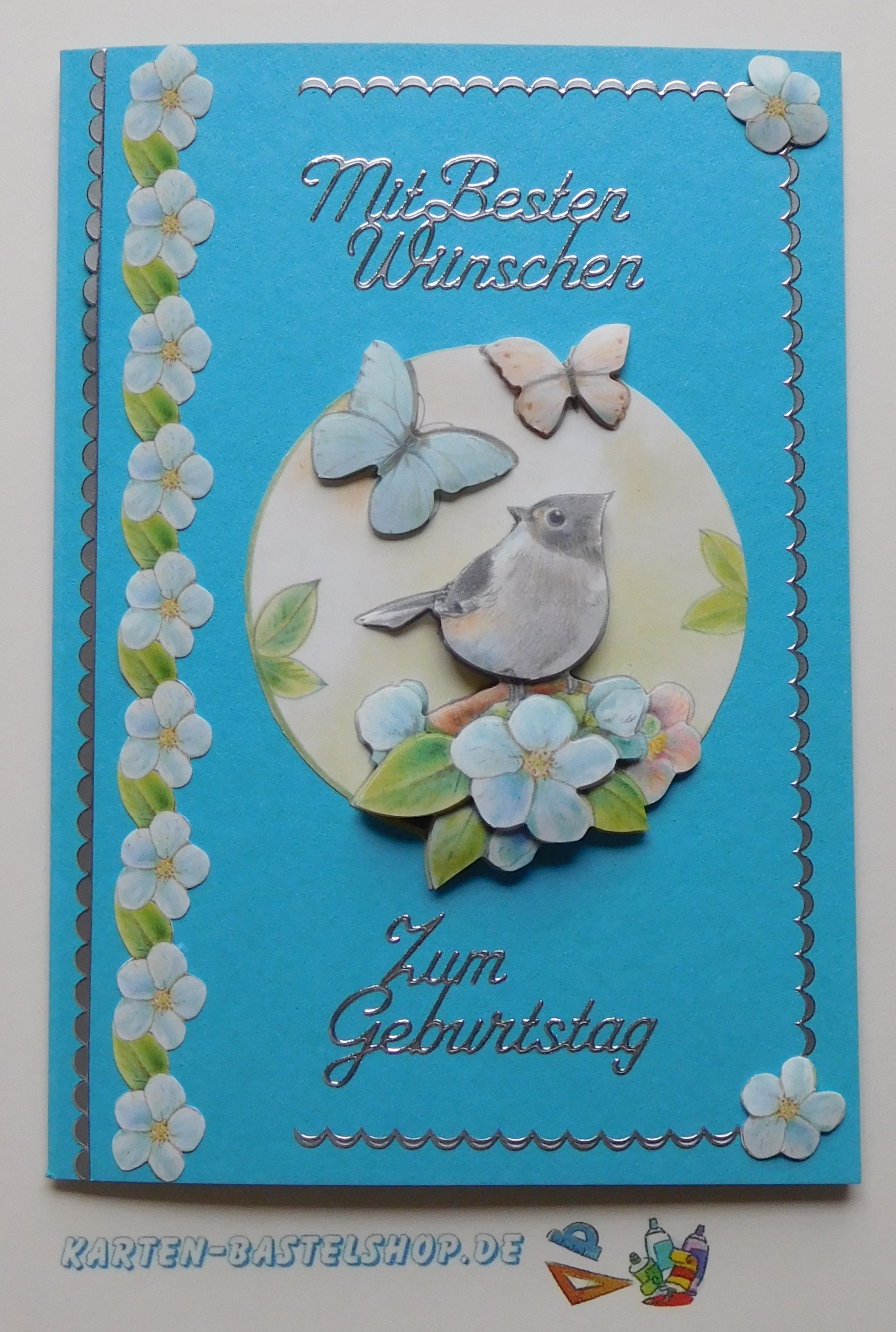 Geburtstagskarte in kräftigem Blau mit Vogelmotiv und silbernen Details aus dem Stanzbogenbuch Nr. 21