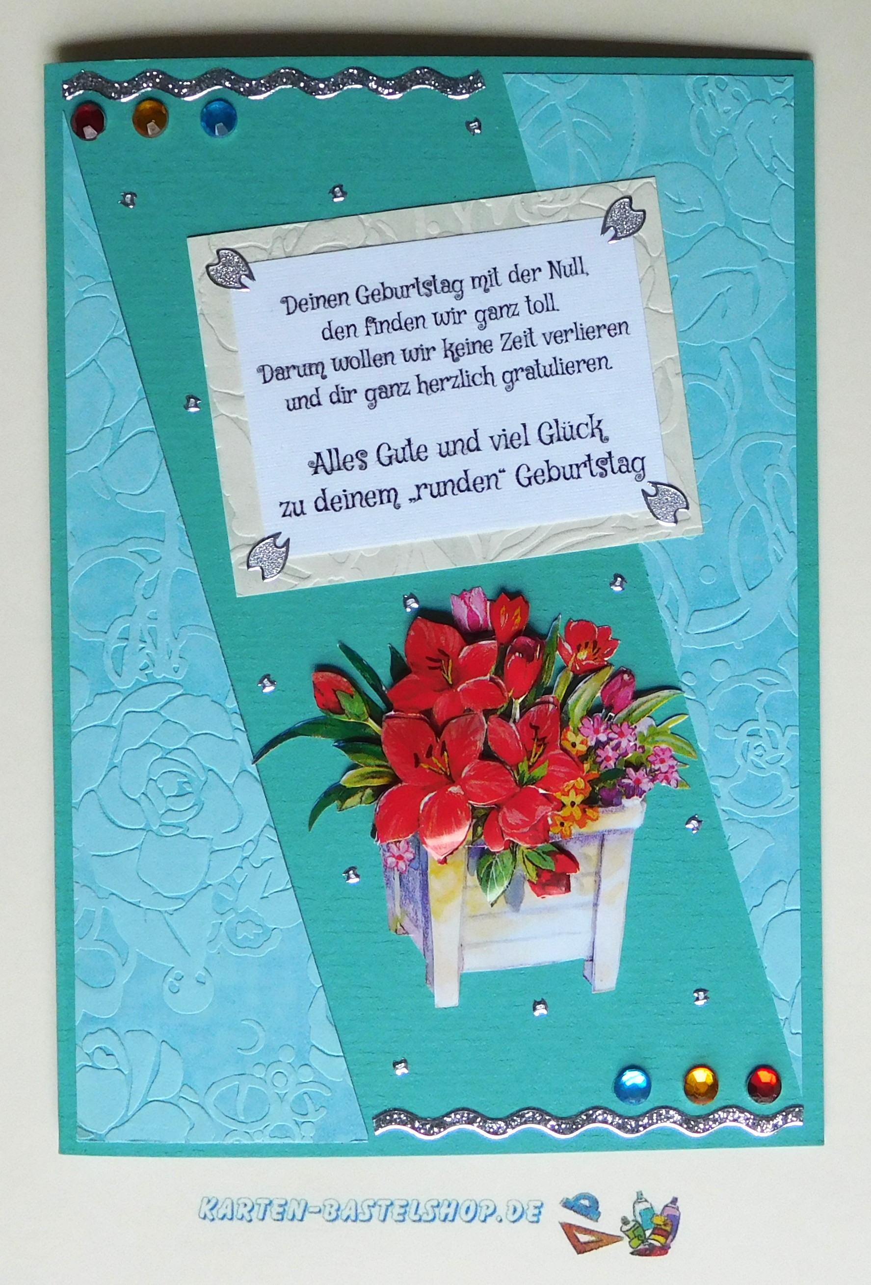 Geburtstagskarte in Türkis mit hellblauen Dreiecken, silbernen Bordüren und Blumenmotiv
