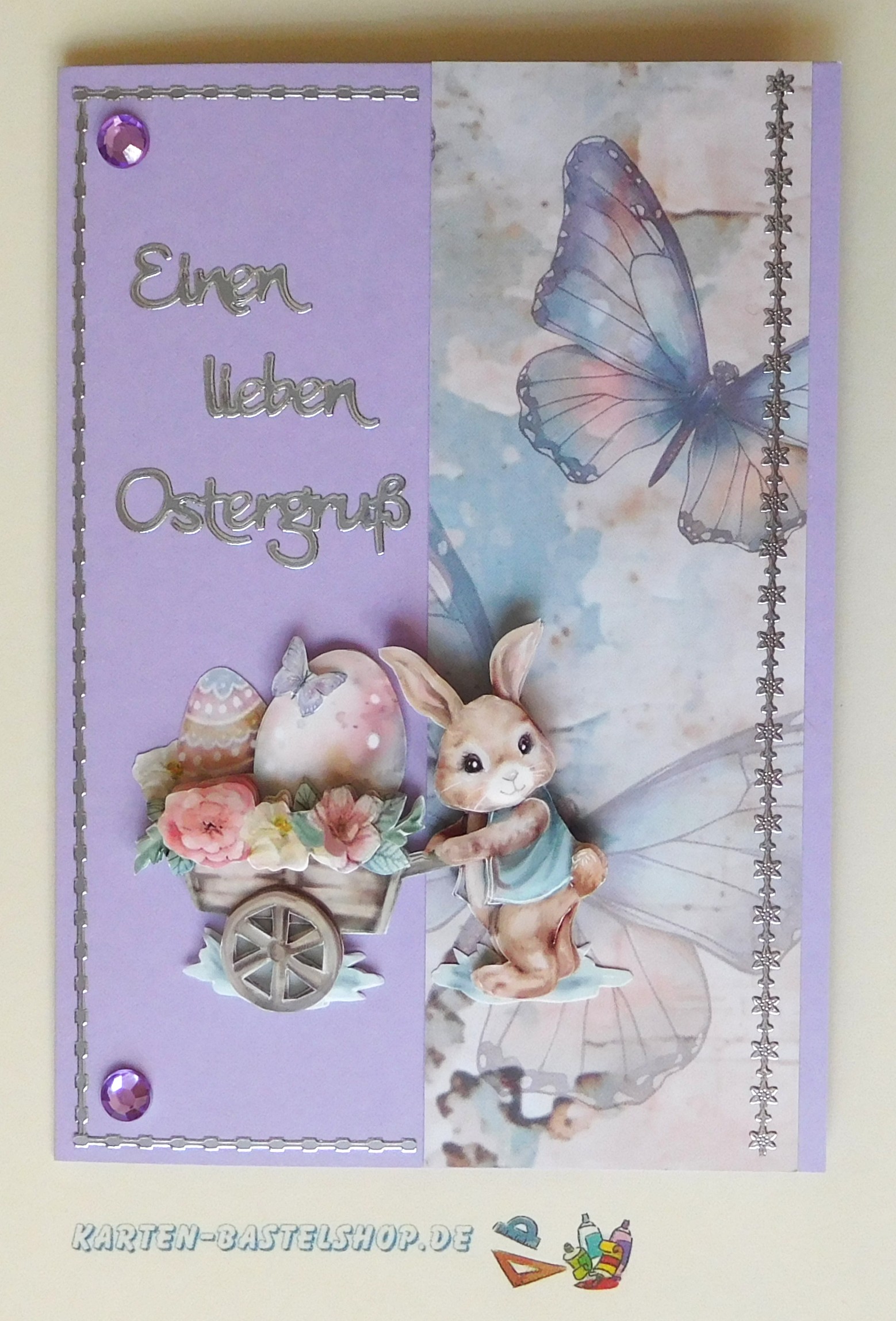 Lila Osterkarte mit Schmetterlingspapier und Hasenmotiv mit Schubkarre